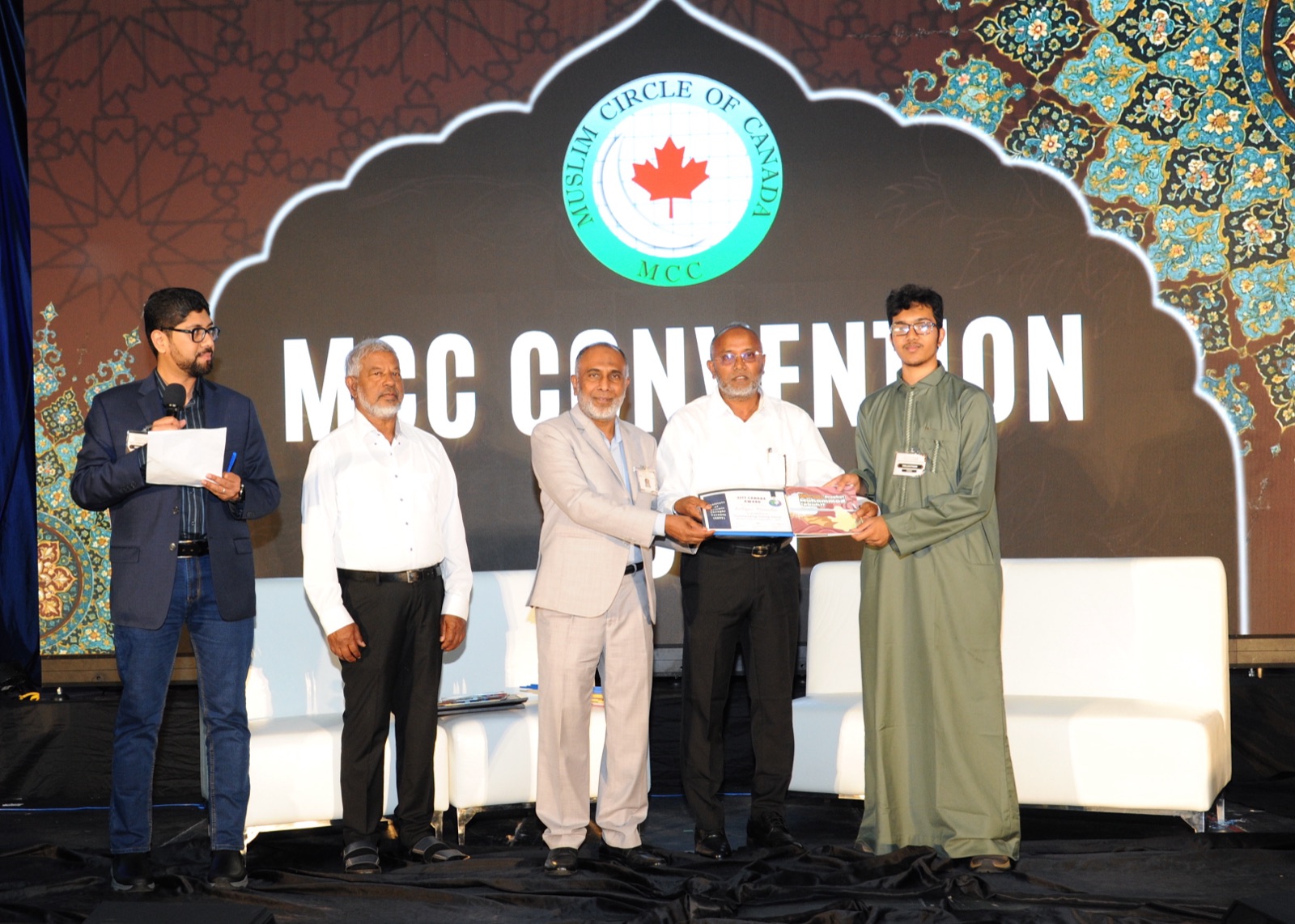 A NextGen youth receives a book award on stage