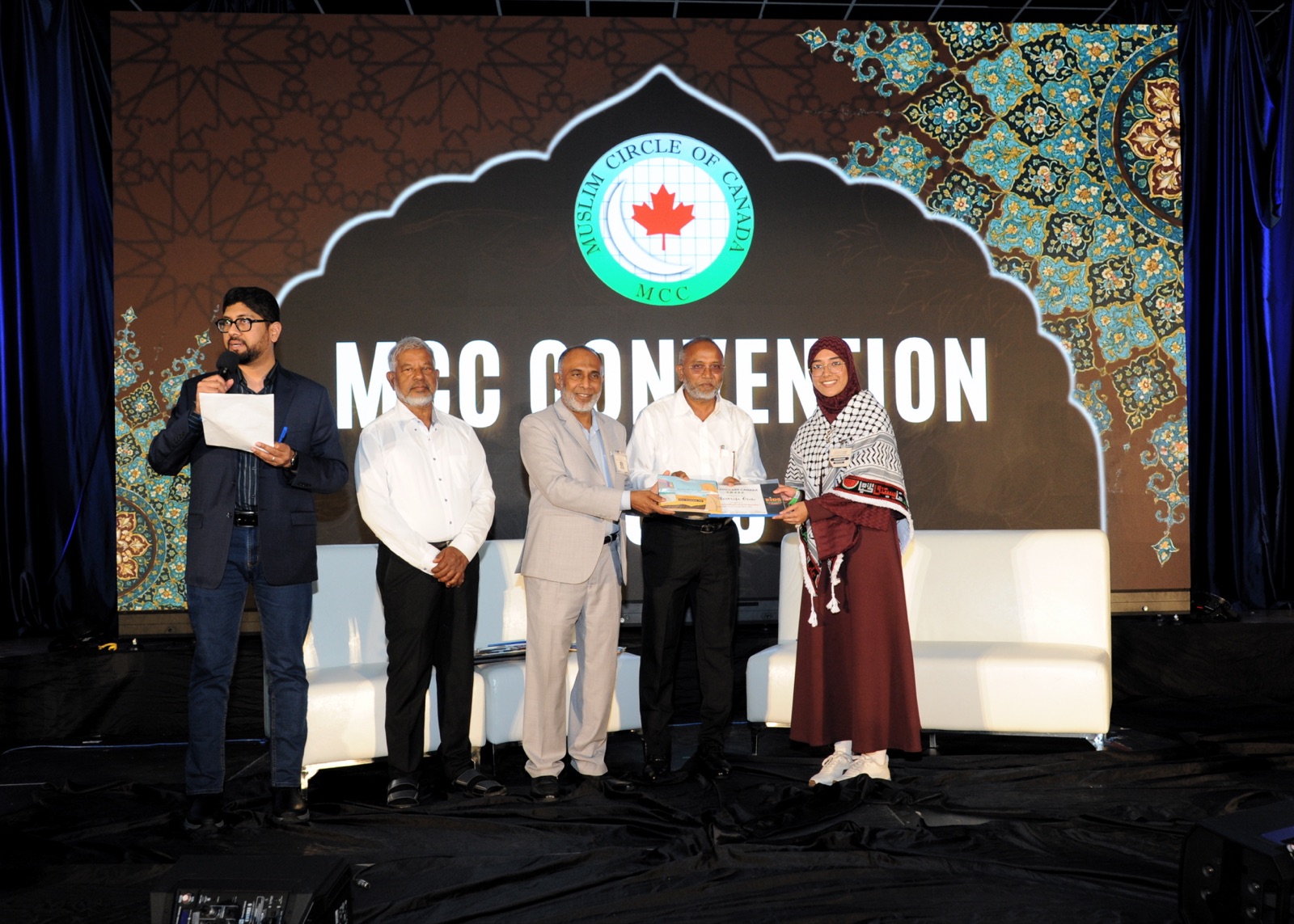 A book award is presented as the host looks on