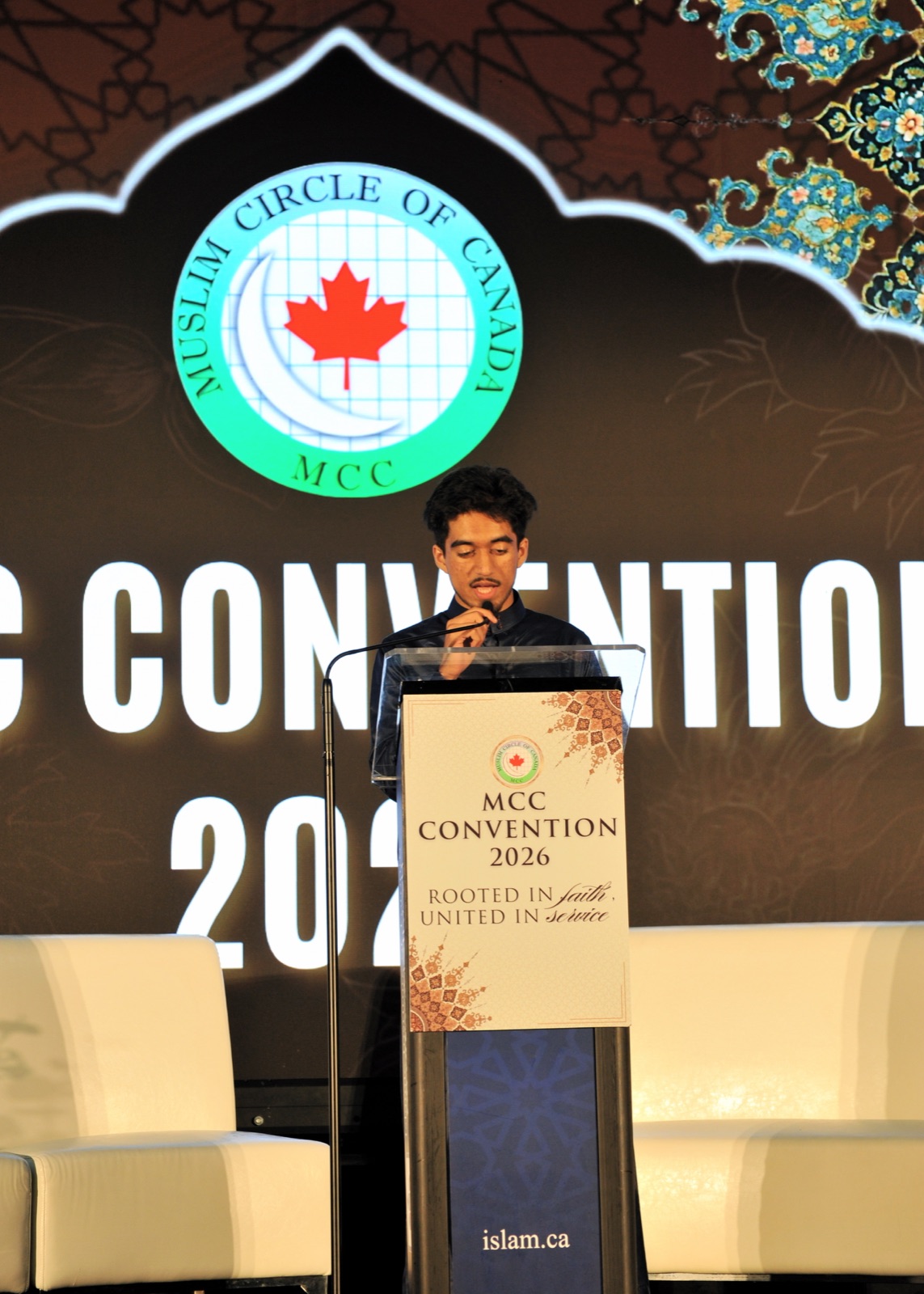 A young man recites at the MCC Convention 2026 podium