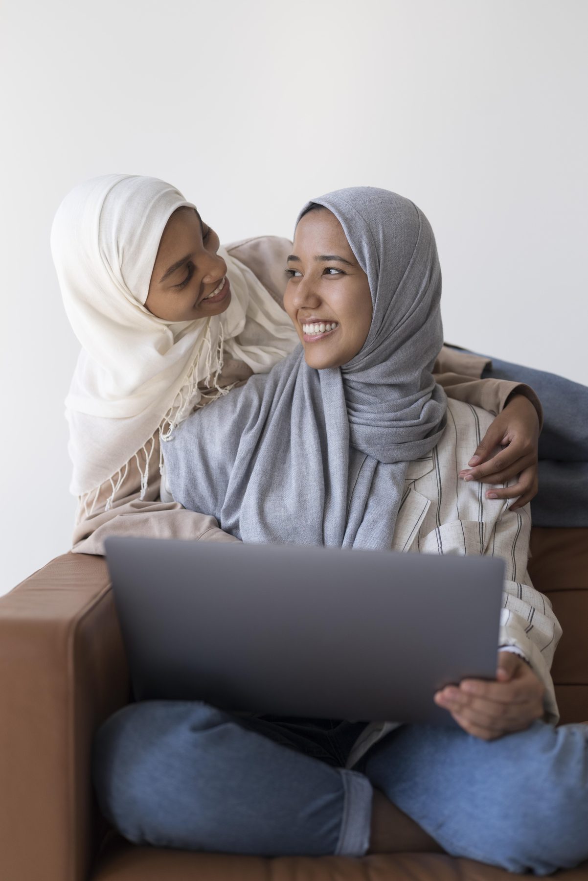 Two young Muslim women learning together with a laptop